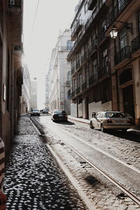 Cars on road amidst buildings in city