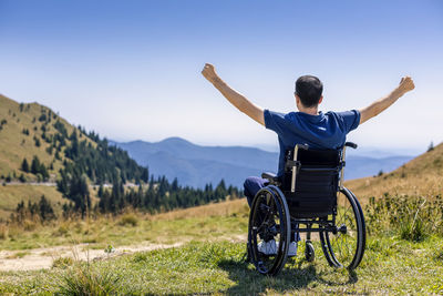 Rear view of man sitting on swing