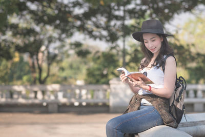 Young woman using mobile phone while sitting outdoors