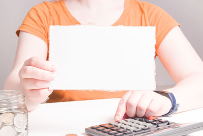 Midsection of woman holding ice cream on table