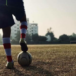 Low section of person playing soccer on field
