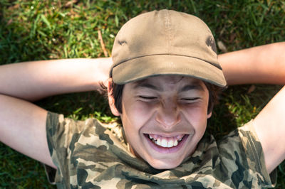 Close-up of smiling boy lying on field