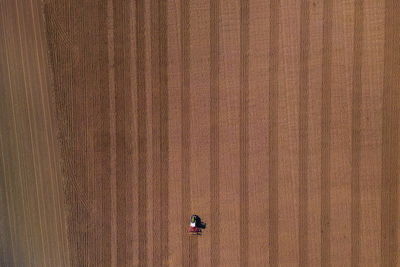 A lonely tractor on a large field directly from above