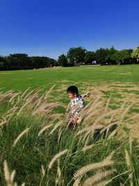 Full length of boy on field against clear sky