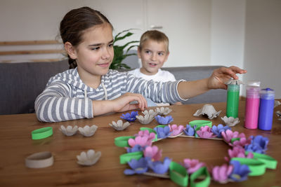 Kids create easter flower wreath in pastel colors using an upcycled egg trail. zero waste lifestyle