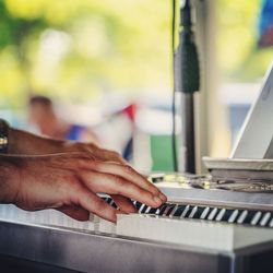 Midsection of man playing piano