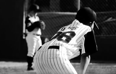 Rear view of boy playing on field