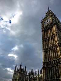 Low angle view of clock tower against cloudy sky