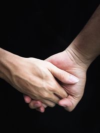 Close-up of hands over black background