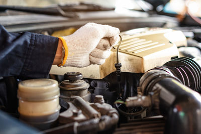 Cropped hands of mechanic repairing car