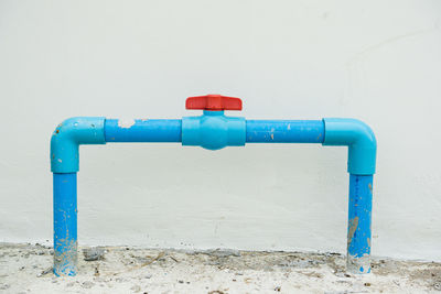 Blue pipe against white wall