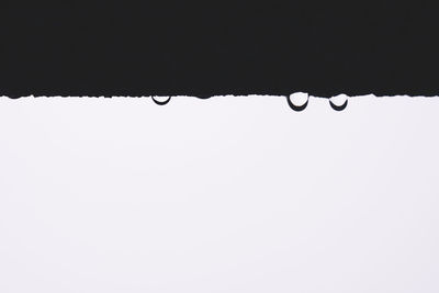 Low angle view of water drops on roof against clear sky