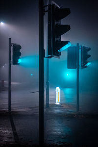 Traffic lights on green in fog at night