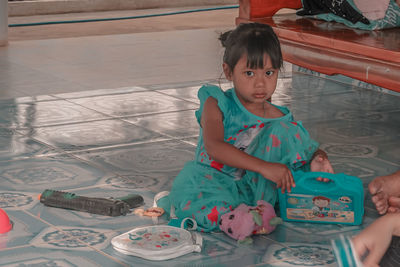 Cute girl sitting on table at home