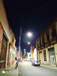 City street amidst buildings at night