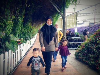 Smiling mother in hijab walking on street