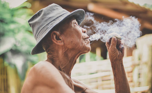 Profile view of senior man smoking outdoors