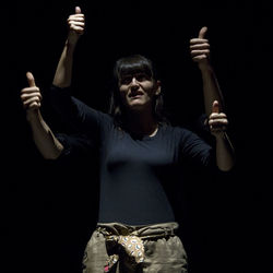 Man and woman showing thumbs up against black background