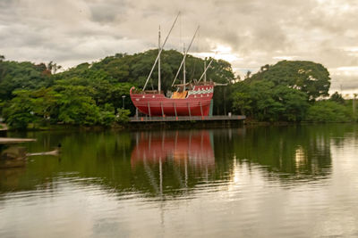 Sailboats moored on lake against sky