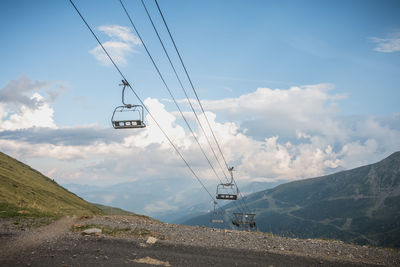 Low angle view of overhead cable car against sky