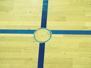 Crossed lines and steel locked cover for training equipment in renewal wooden floor of sports hall