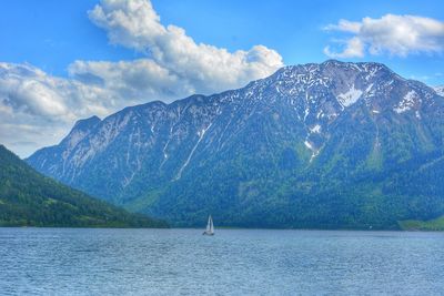 Scenic view of lake by mountains against sky