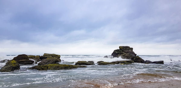 Rocks on beach against sky