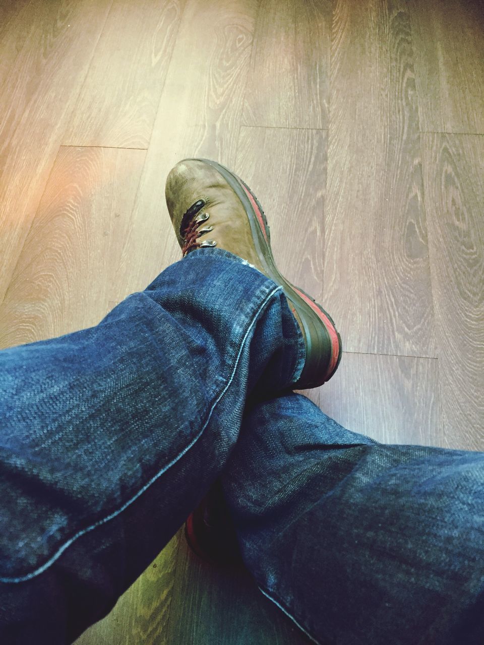 LOW SECTION OF MAN WEARING SHOES ON FLOOR