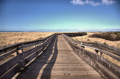 View of empty dirt road against sky