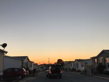 Traffic on road in city against clear sky