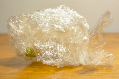 Close-up of crumpled plastic bag on wooden table