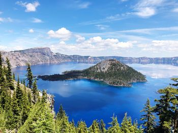 Scenic view of lake by trees against sky