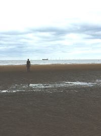 Man standing on beach against sky