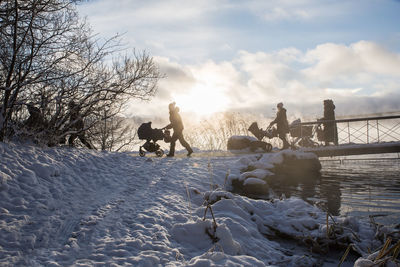 Silhouettes of people with prams