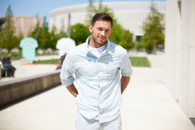 Portrait of young man standing in city
