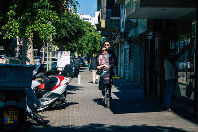 People riding bicycles on sidewalk in city
