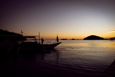 Silhouette sailboats in sea against clear sky during sunset
