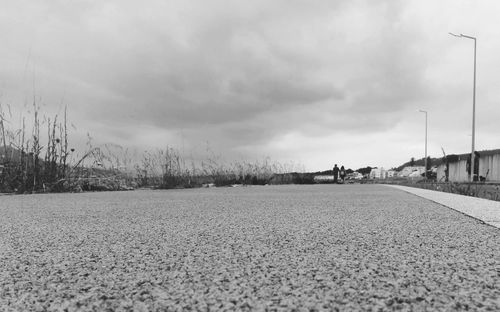 Surface level of road on field against sky