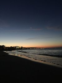 Scenic view of beach against sky at sunset