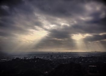 Aerial view of cityscape against cloudy sky