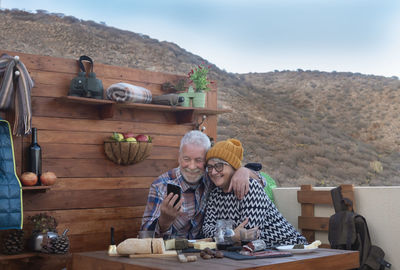 Close-up of senior couple sitting against mountains