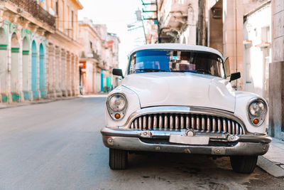 Vintage car on street against buildings