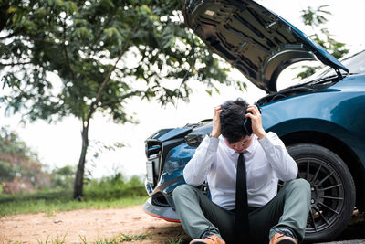 Side view of woman sitting on car