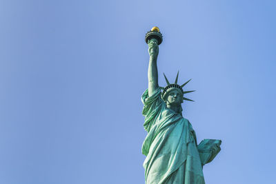 Low angle view of statue against blue sky