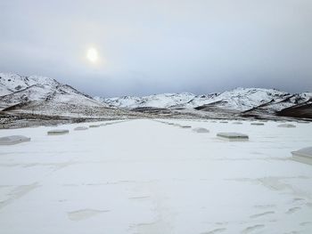 Scenic view of frozen lake against sky during winter