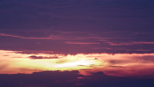 Low angle view of silhouette airplane against sky during sunset