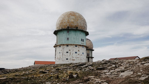 Low angle view of lighthouse on building against sky