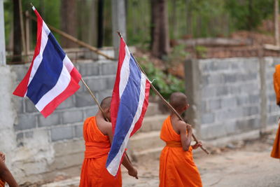 Rear view of men flag against built structure