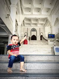 Full length of girl sitting on staircase