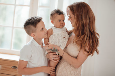 Mother and daughter against wall